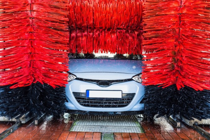 Lavadora automática limpie el coche azul en la estación de lavado automático. Fondo automático de lavadora de coches