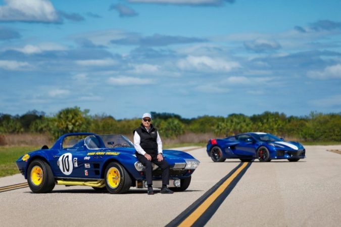 Corvette Grand Sport clásico azul y Corvette C8 moderno en pista, comparativa generaciones, autos deportivos Chevrolet, cielo despejado, enfoque en diseño y herencia de competición.