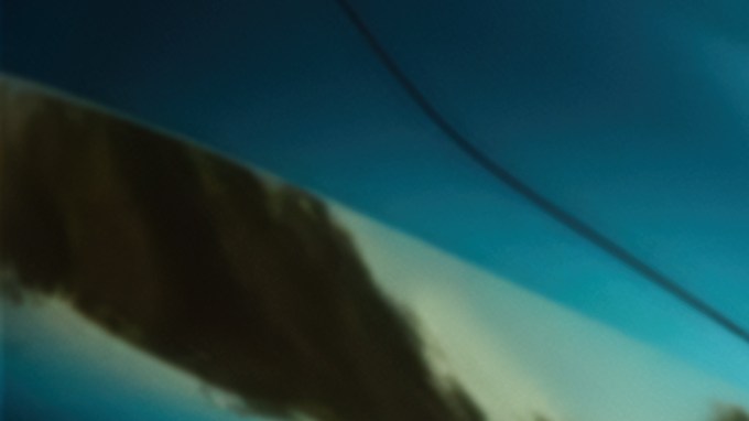 Vista lateral de ángulo bajo de los corridos de autos a lo largo de la autopista al atardecer