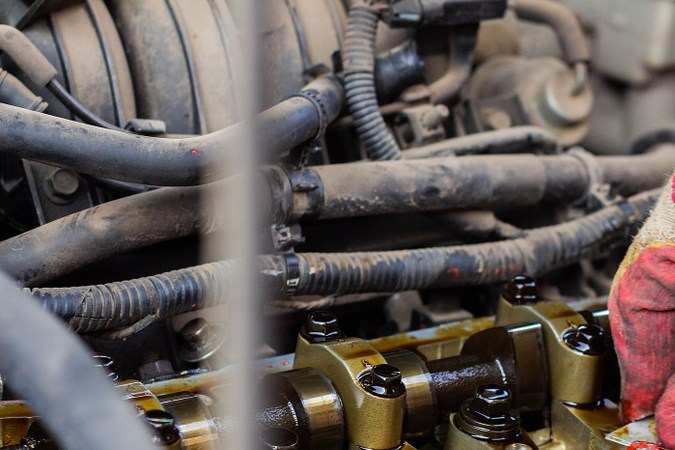 Mecánico realizando reparación de junta de culata en motor de auto, proceso de cambio y mantenimiento del sistema de culata.