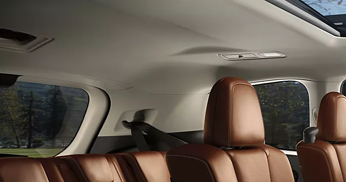 Interior amplio del Subaru Ascent 2026 con asientos en cuero, techo solar panorámico y vista a campo abierto