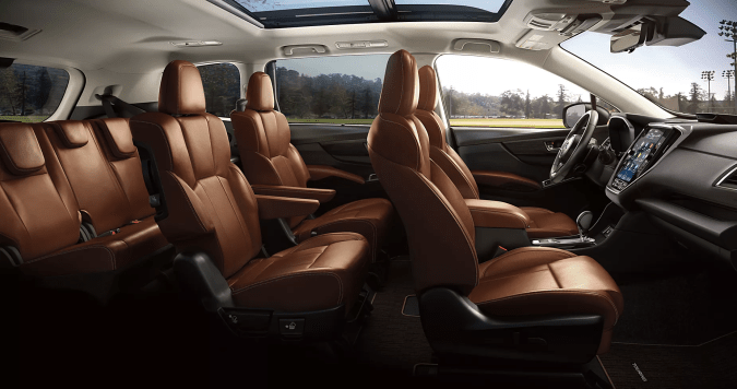 Interior amplio del Subaru Ascent 2026 con asientos en cuero, techo solar panorámico y vista a campo abierto