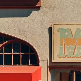 Hyundai Santa Cruz 2026 estacionada frente a tienda de surf, vista lateral de la pickup compacta urbana.