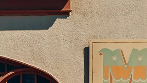 Hyundai Santa Cruz 2026 estacionada frente a tienda de surf, vista lateral de la pickup compacta urbana.