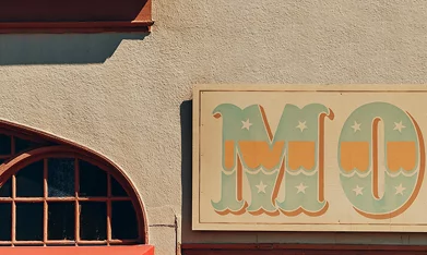 Hyundai Santa Cruz 2026 estacionada frente a tienda de surf, vista lateral de la pickup compacta urbana.