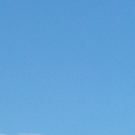 Dos Subaru Outback Wilderness, verde y azul, estacionados en un paisaje rocoso y árido con montañas al fondo.