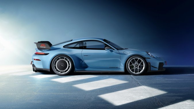 Porsche 911 GT3 2026 con kit Manthey en color azul, vista lateral destacando el alerón y llantas forjadas