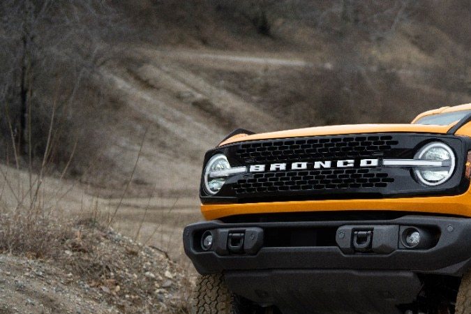 Ford Bronco Wildtrak 2026 naranja subiendo rocas off-road en terreno difícil