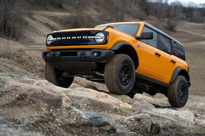 Ford Bronco Wildtrak 2026 naranja subiendo rocas off-road en terreno difícil