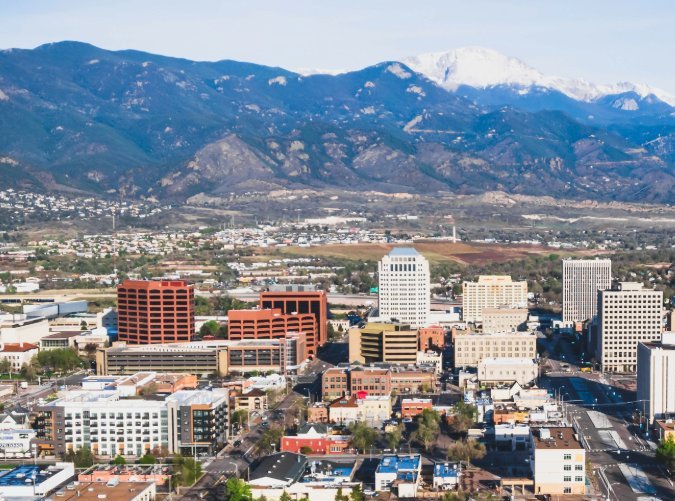 Vista panorámica de Colorado Springs con autopistas y montañas nevadas, ideal para temas de radares de velocidad en carreteras de Colorado