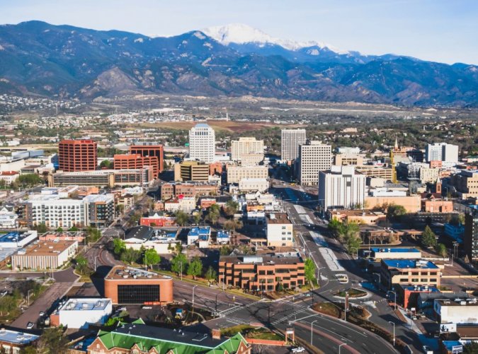 Vista panorámica de Colorado Springs con autopistas y montañas nevadas, ideal para temas de radares de velocidad en carreteras de Colorado