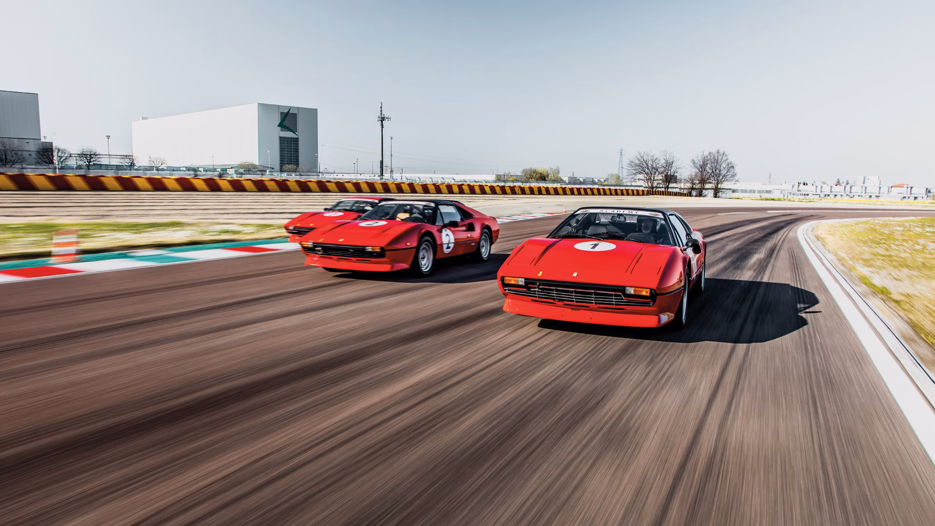 Ferrari 308 GTB y GTS rojos en pista, dos deportivos clásicos italianos en conducción de alto rendimiento