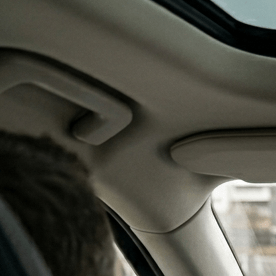 Conductor en un Volvo XC90 con una pequeña pantalla central de Android Automotive y panel de madera.