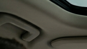 Conductor en un Volvo XC90 con una pequeña pantalla central de Android Automotive y panel de madera.