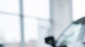 Calendario con fecha marcada, dinero y llave de auto en concesionario, imagen sobre comprar carro a fin de mes