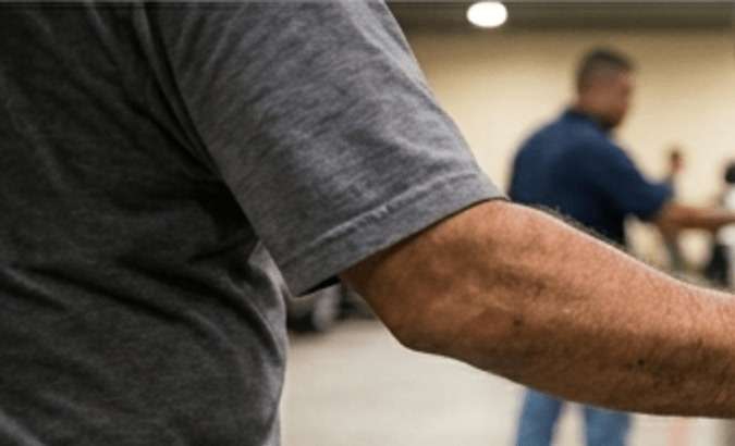 Comprador inspeccionando Ford F-150 en subasta de vehículos incautados en Texas