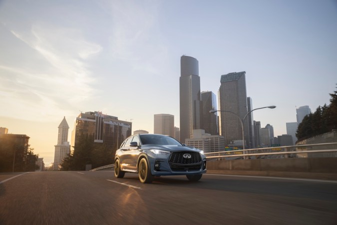 Infiniti QX50 circulando en ciudad al atardecer, SUV premium con diseño moderno y enfoque urbano.