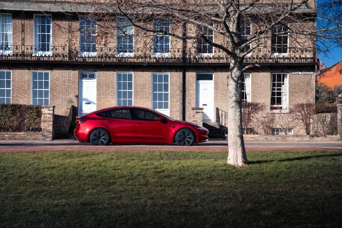 Tesla Model 3 2026 de color rojo escarlata frente a edificio europeo
