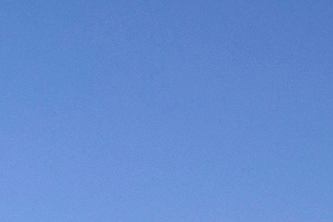 Scout Terra pick-up eléctrica gris estacionada en campo seco al atardecer, vista lateral completa.