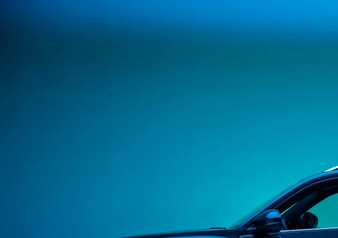 Vista lateral VW Atlas 2027 R-Line Sacramento Green en ambiente nocturno: iluminación LED y líneas dinámicas del renovado SUV mediano familiar.