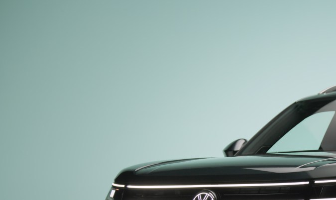 Vista frontal tres cuartos VW Atlas 2027 R-Line en color Sacramento Green: faros LED iluminados y parrilla moderna del nuevo SUV de Volkswagen.