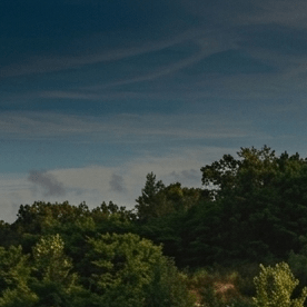Imagen dividida comparando un SUV Jeep plateado en terreno de tierra y un SUV Toyota azul en una entrada de piedra.