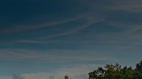 Imagen dividida comparando un SUV Jeep plateado en terreno de tierra y un SUV Toyota azul en una entrada de piedra.