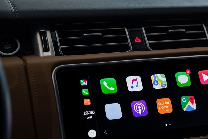 Menú principal de Apple CarPlay en el coche ejecutivo. Interior de coche de cuero recortado por la noche, foto de primer plano del sistema de infoentretenimiento.