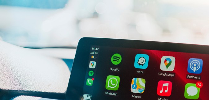 Detalles de las aplicaciones e iconos en la pantalla principal de Apple CarPlay en el salpicadero del coche moderno durante la conducción