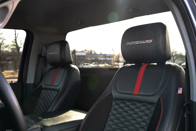 Interior Ford F-150 Nitemare 2026 con asientos de cuero negro, detalles rojos y emblemas Nitemare.