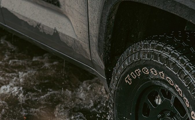 Neumático Firestone Destination en pickup Toyota Tundra atravesando agua, imagen enfocada en tracción y uso off-road