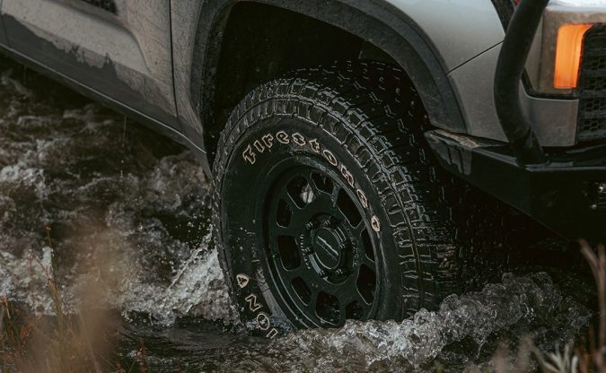 Neumático Firestone Destination en pickup Toyota Tundra atravesando agua, imagen enfocada en tracción y uso off-road