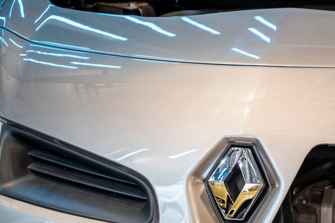 Motor híbrido TWINe de Renault expuesto en el vano motor de un automóvil plateado: detalle frontal con sistema de propulsión electrificada Twin Electric.