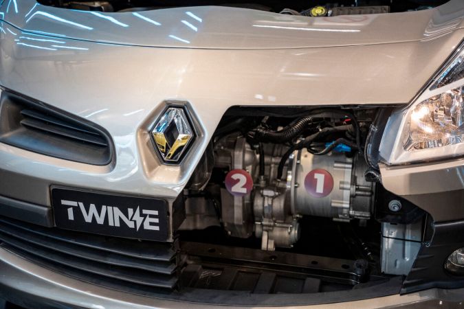 Motor híbrido TWINe de Renault expuesto en el vano motor de un automóvil plateado: detalle frontal con sistema de propulsión electrificada Twin Electric.
