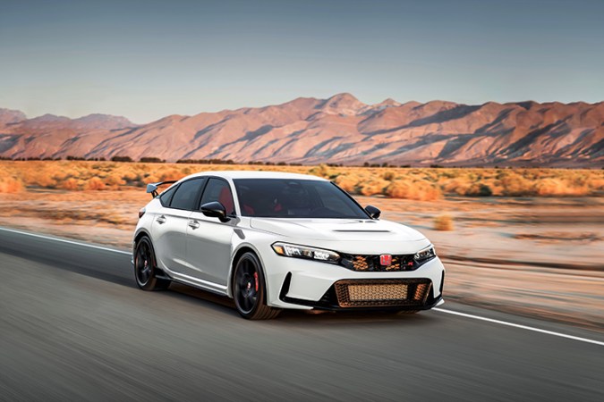 Honda Civic Type R 2025 blanco circulando en carretera desértica, con diseño deportivo, alerón trasero y llantas de alto rendimiento.