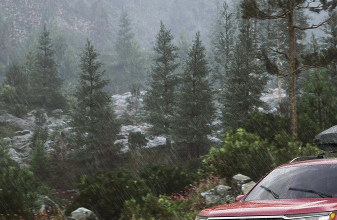 Honda Pilot Elite 2026 roja en camino off-road bajo la lluvia con roof box