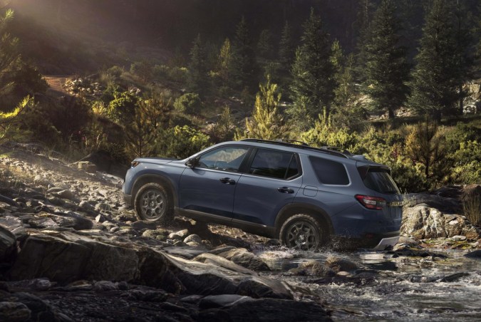 Honda Pilot TrailSport 2026 azul atravesando río en terreno rocoso todoterreno