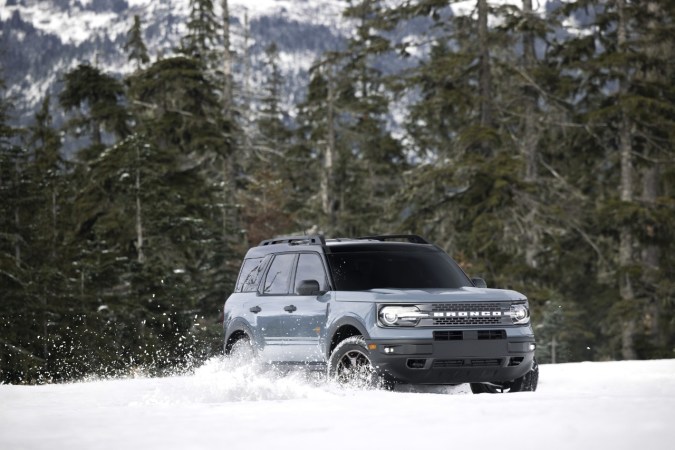 SUV Ford Bronco Sport azul conduciendo en nieve, demostrando capacidad off-road y rendimiento 4x4 en clima extremo.