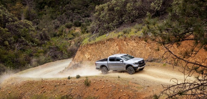Camioneta Ford Ranger Lariat plateada de frente circulando off-road en camino irregular durante pruebas de manejo.