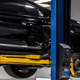 Mercedes-Benz negro en taller de blindaje, técnico trabajando en puerta desmontada para instalar protección balística y reforzar carrocería