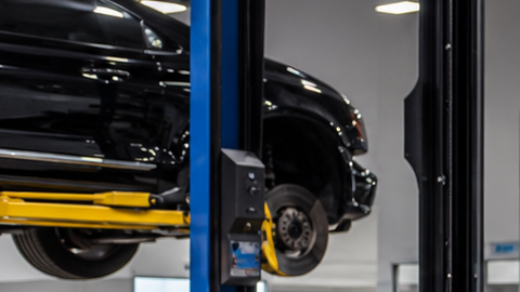 Mercedes-Benz negro en taller de blindaje, técnico trabajando en puerta desmontada para instalar protección balística y reforzar carrocería
