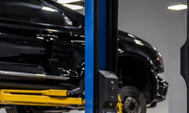 Mercedes-Benz negro en taller de blindaje, técnico trabajando en puerta desmontada para instalar protección balística y reforzar carrocería