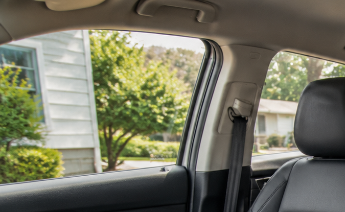 Interior de SUV con asientos de cuero negros y una silla infantil instalada en la segunda fila, mostrando configuración de asientos y seguridad para niños.