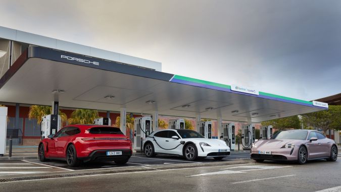 Tres Porsche Taycan eléctricos cargando en estación ultrarrápida Porsche e Iberdrola, coches deportivos enchufados en cargadores rápidos para vehículos eléctricos en España