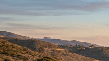 “Tesla Model 3 azul y Tesla Model Y rojo circulando por carretera costera al atardecer, autos eléctricos en carretera panorámica junto al mar en 2026