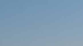 Un SUV eléctrico blanco conduciendo por una autopista al atardecer.
