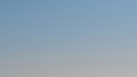 Un SUV eléctrico blanco conduciendo por una autopista al atardecer.