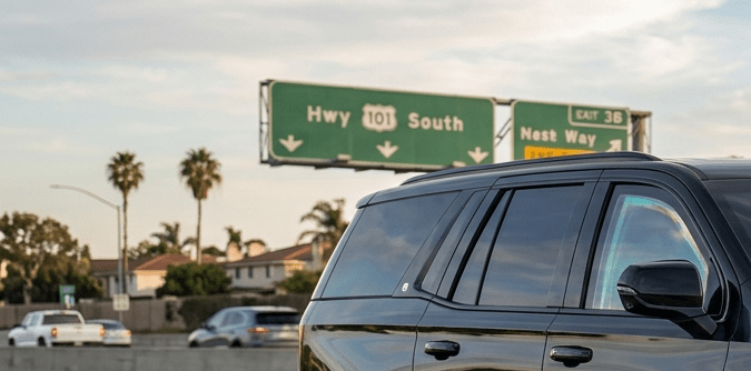 Cadillac Escalade negra blindada circulando por autopista en Estados Unidos, SUV de lujo con protección balística y vidrios antibalas en movimiento.