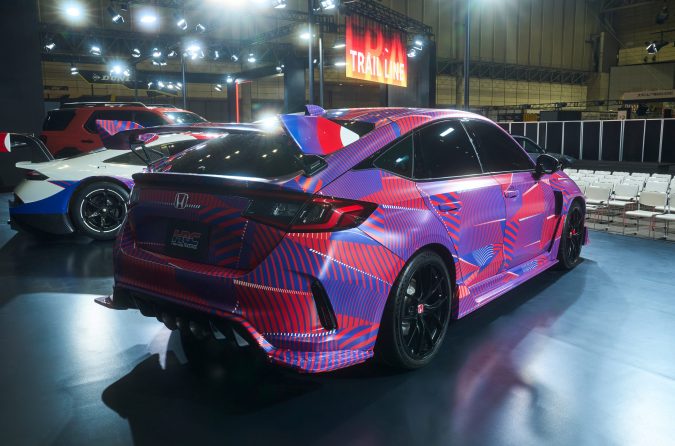 Honda Civic Type R camuflado en Tokyo Auto Salon 2026, exhibido en un evento automotriz con diseño deportivo y alerón trasero.