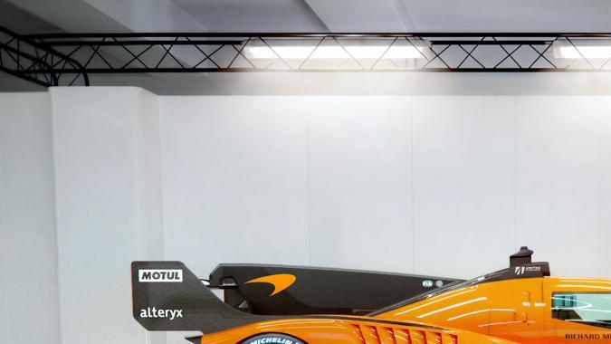 McLaren Hypercar GTR naranja de perfil en estudio, prototipo de resistencia con diseño aerodinámico y neumáticos Michelin.